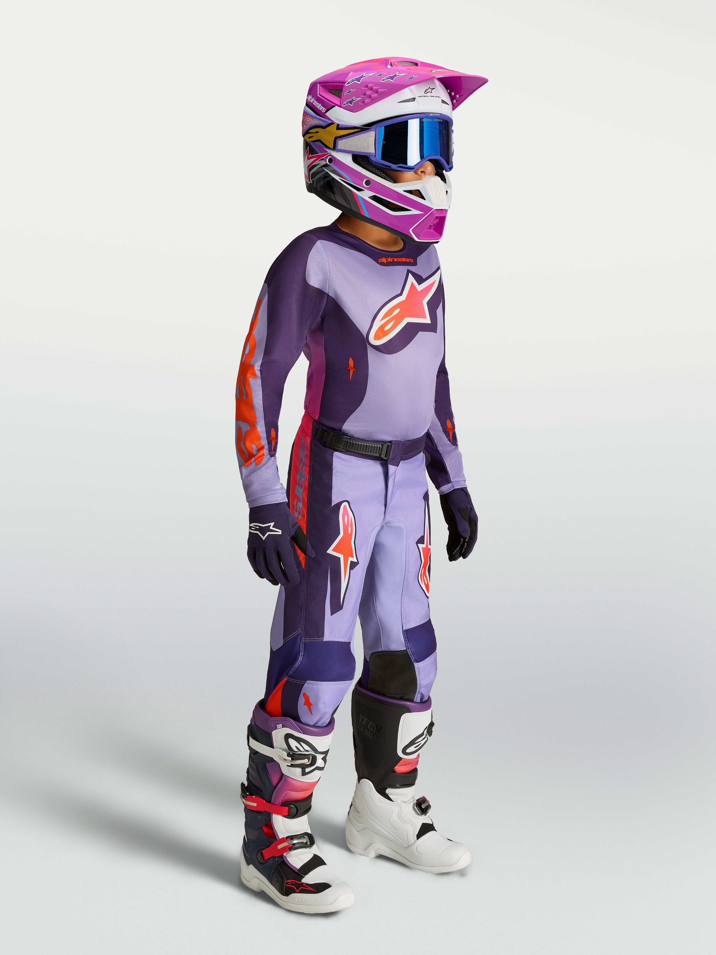 Młodzieżowy zestaw Alpinestars 2027 Fluid Hunt, fioletowy i różowy fluo, koszulka i spodnie motocrossowe na modelu.