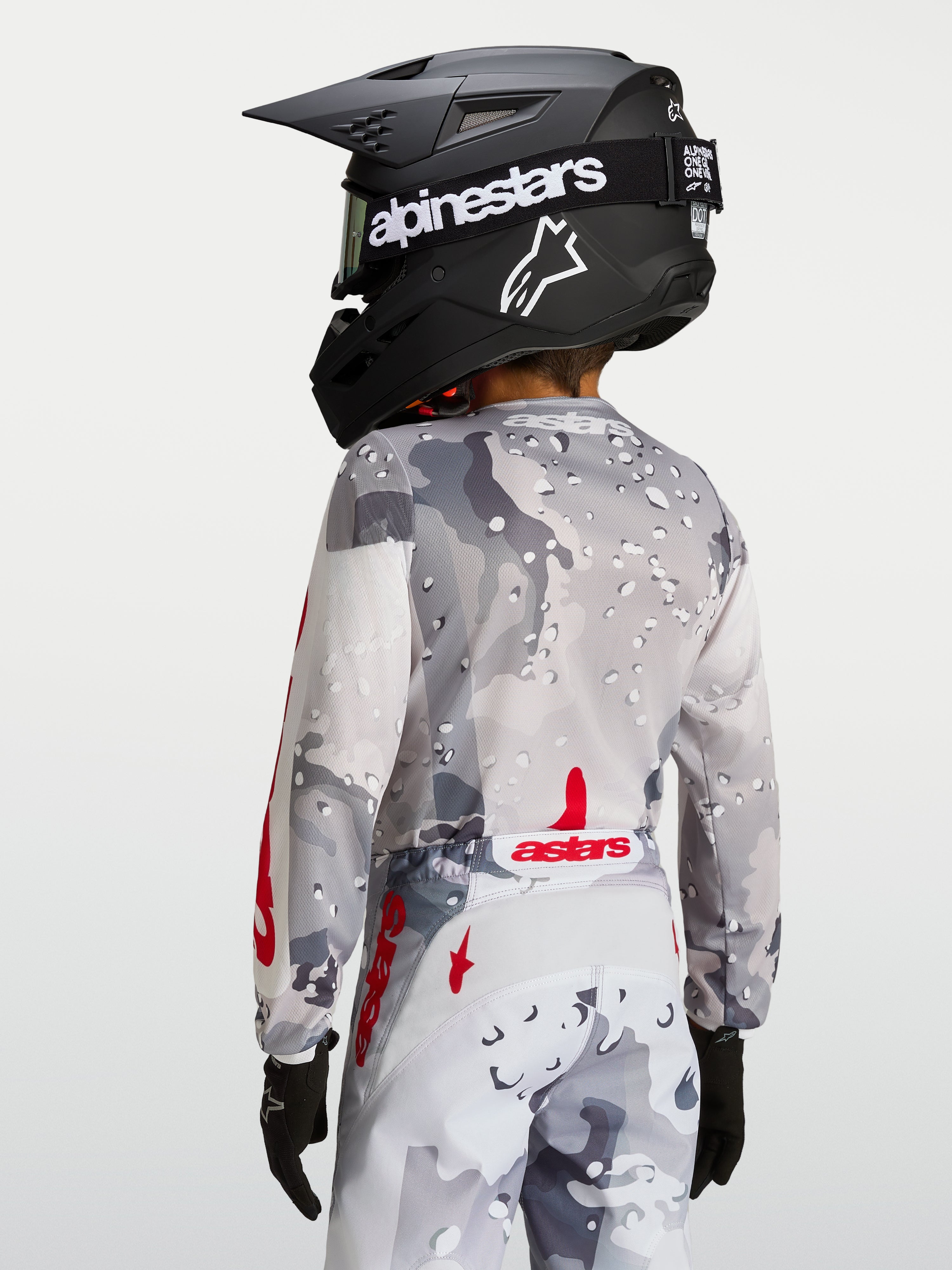 Koszulka Alpinestars Fluid Lone Młodzieżowe, szary kamuflaż i czerwony, widok z tyłu pokazujący ergonomiczny krój i wydłużony tył, profesjonalna odzież motocrossowa