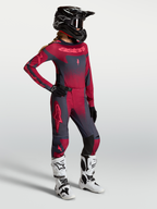 Alpinestars Stella Techstar Swan Gear Set oraz Spodnie Stella Techstar Swan, damska odzież motocrossowa, kolor karmazynowy i szary, modelka w kasku i białych butach.