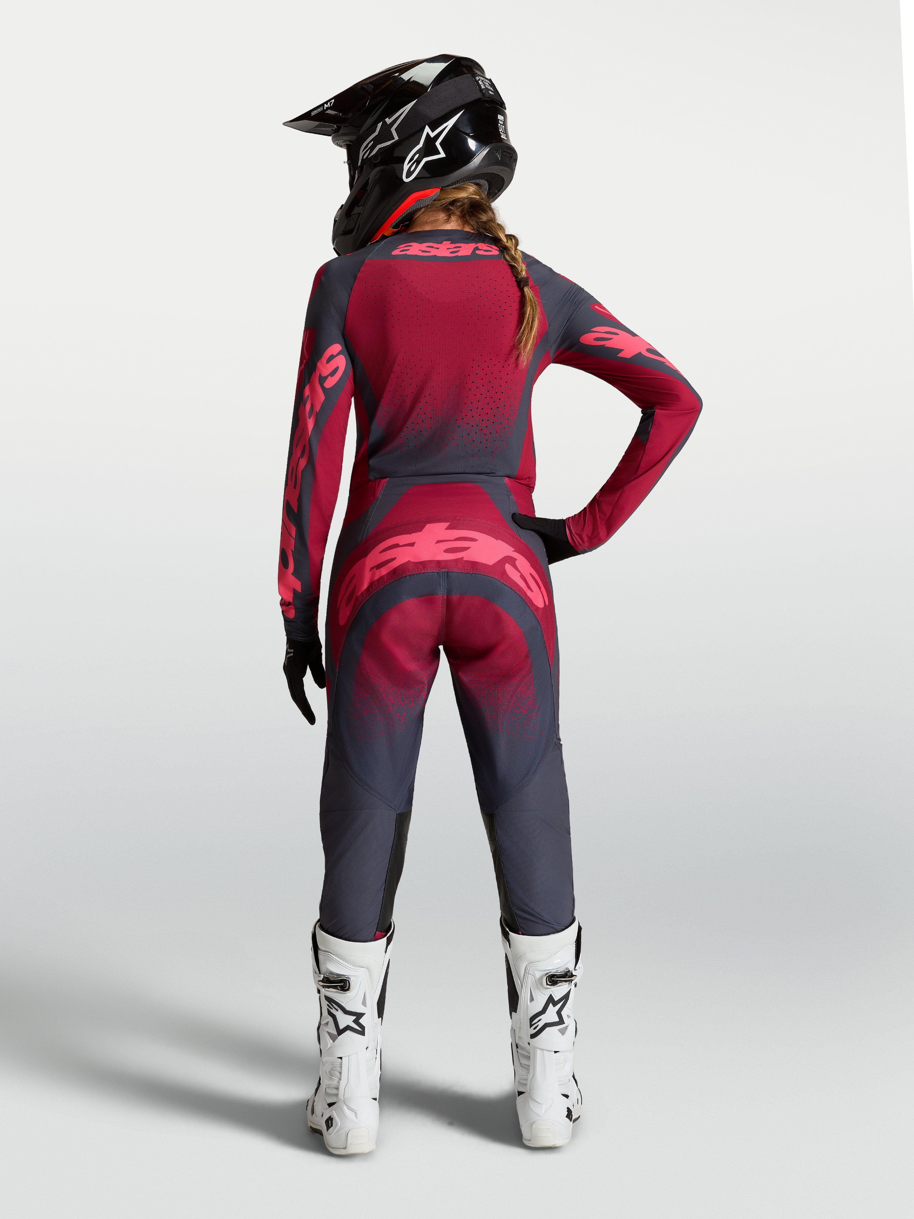 Koszulka Stella Techstar Swan, damska koszulka motocrossowa MX, czerwona i ciemnoszara, widok od tyłu na modelce, wentylowany materiał i sportowy krój.