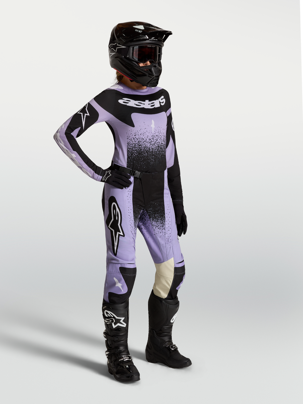 Alpinestars Stella Techstar Swan Gear Set i Koszulka, damski zestaw motocrossowy, jasnofioletowy i czarny, z grafiką swan, prezentowany na modelu w kasku i butach terenowych.