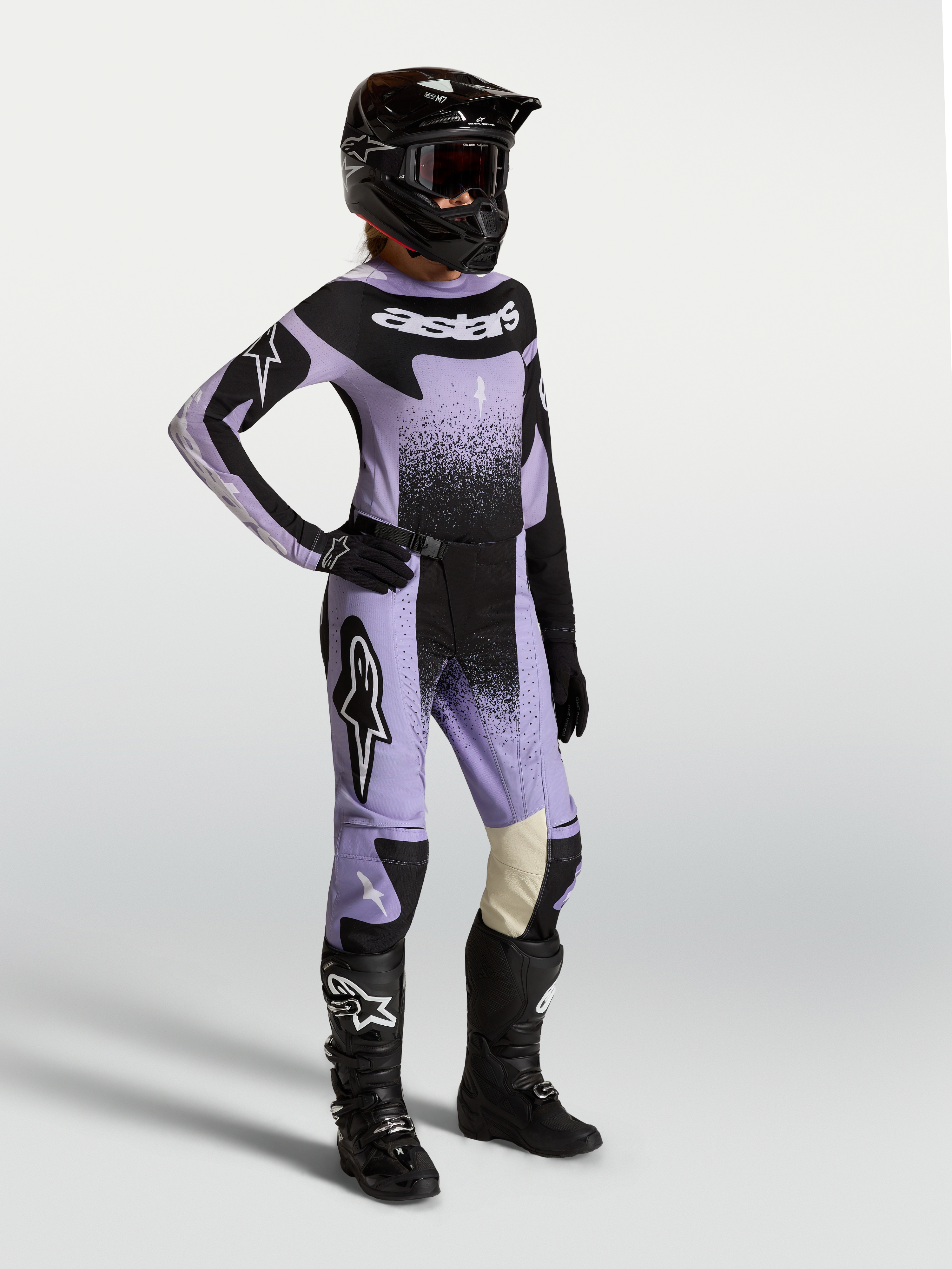 Alpinestars Stella Techstar Swan Gear Set i Koszulka, damski zestaw motocrossowy, jasnofioletowy i czarny, z grafiką swan, prezentowany na modelu w kasku i butach terenowych.