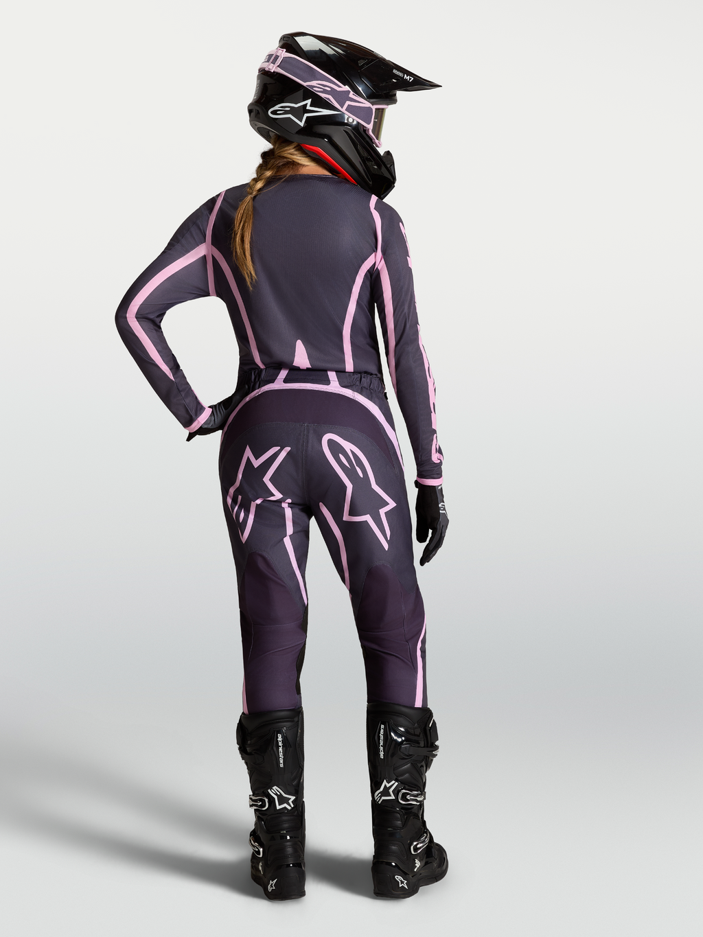 Spodnie Alpinestars Stella Fluid Apex V2, damskie spodnie motocrossowe, szare i r3sowe, widok z tyłu na zawodniczkę w pasującym komplecie odzieży MX.