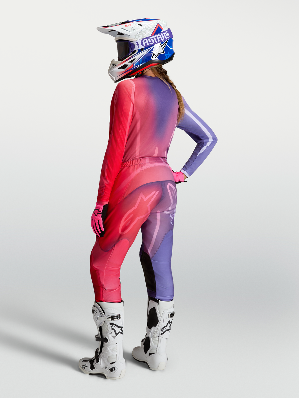 Damska koszulka motocrossowa Alpinestars Stella Fluid Kepler, fioletowa i czerwona, widok z tyłu ze spodniami i butami.