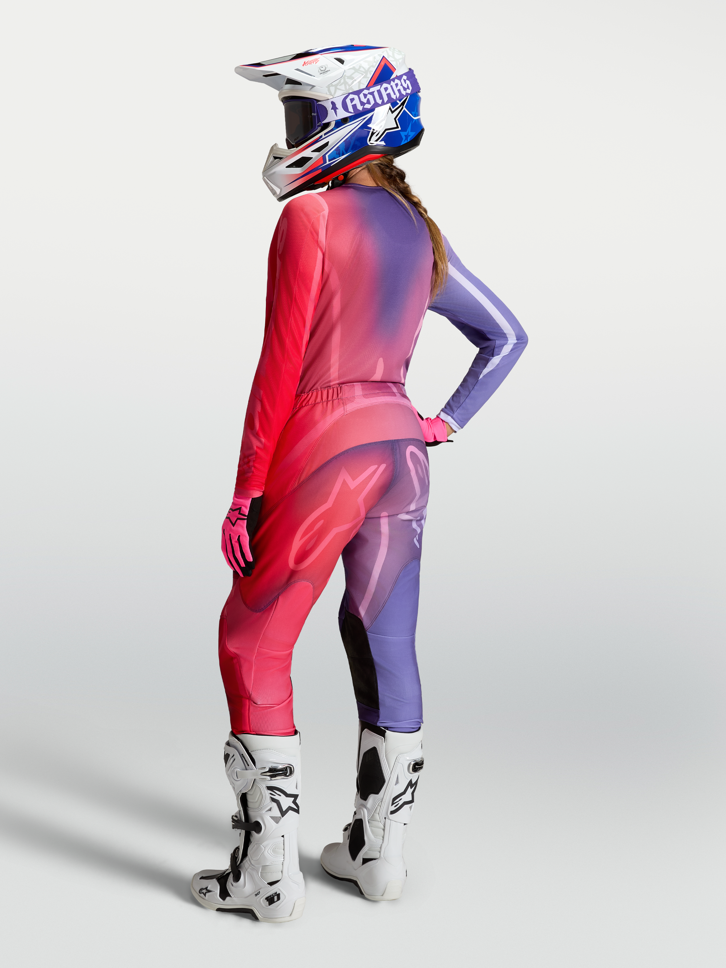 Damska koszulka motocrossowa Alpinestars Stella Fluid Kepler, fioletowa i czerwona, widok z tyłu ze spodniami i butami.