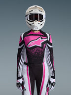 Alpinestars 2026 Stella Techstar Nomur Gear Set, damski strój motocrossowy, różowo-czarno-biały z dużym logo gwiazdy, dopasowana koszulka, spodnie i rękawice, biały kask, widok z przodu na szarym tle