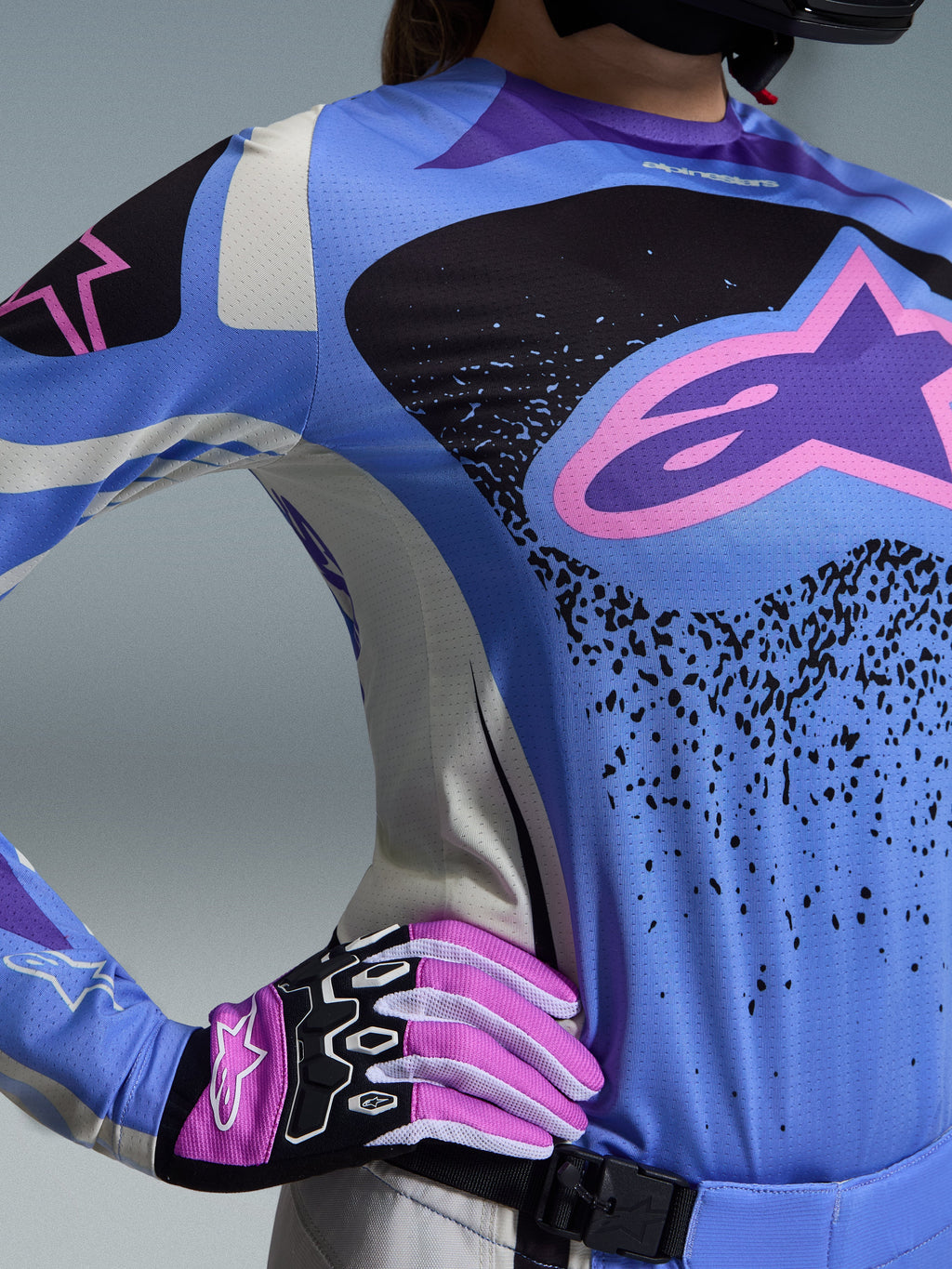 Alpinestars Stella Techstar Nomur 2026, damski zestaw motocrossowy, jasnoniebieski i czarny z różowym logo gwiazdy, dopasowane różowo-białe rękawice, sportowy krój wyścigowy zapewniający wysoką wydajność w każdym terenie