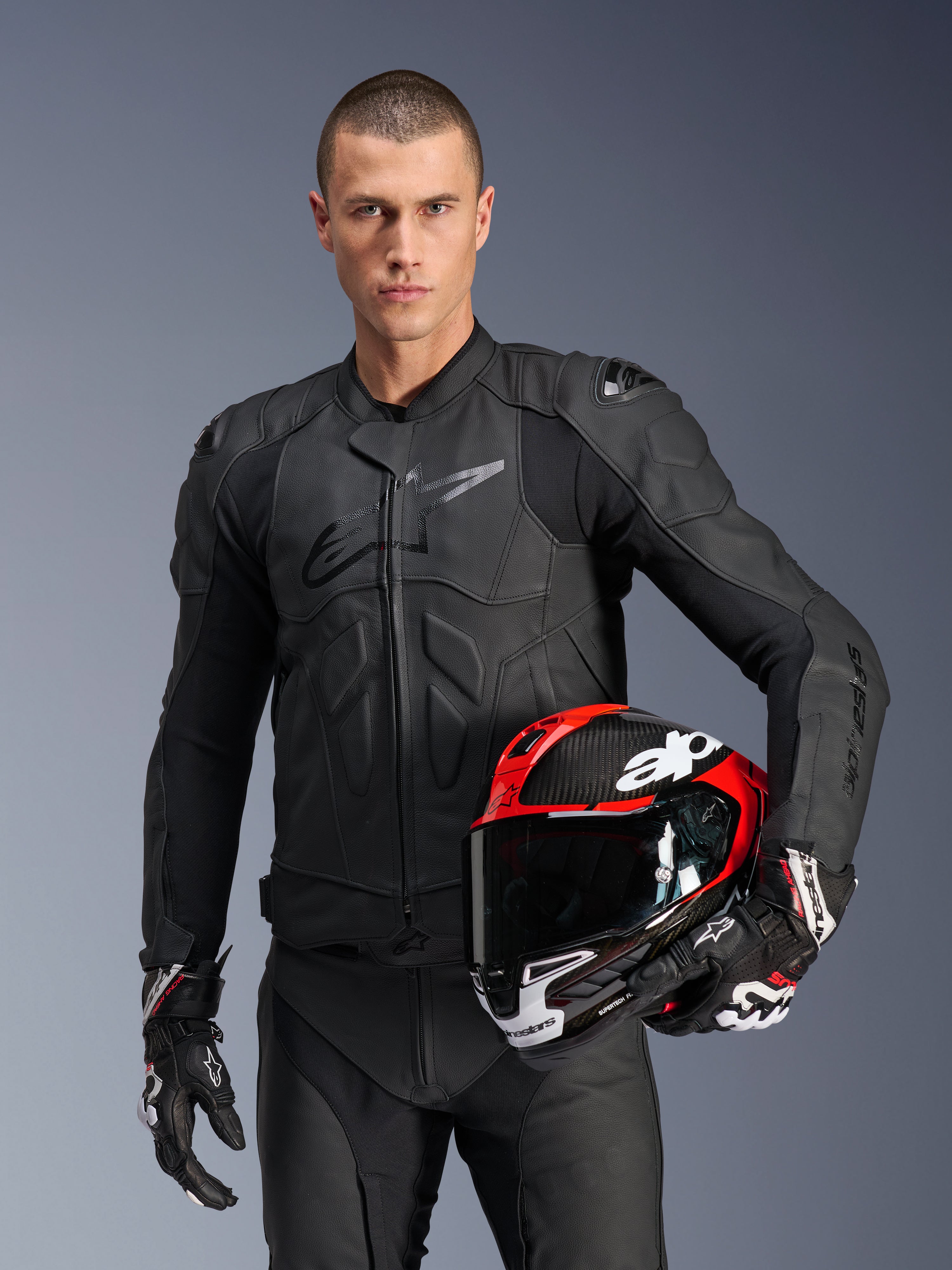 Alpinestars kurtka Dusk skórzana, męska kurtka motocyklowa wyścigowa, czarna, ochrona Nucleon PLASMA, z czerwonym kaskiem.