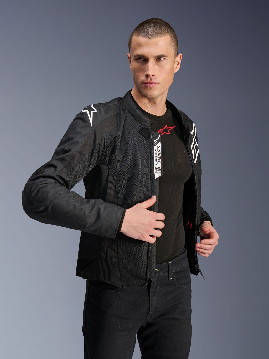 Kurtka Alpinestars Viper Air V4, czarna tekstylna kurtka motocyklowa, noszona przez modela z czarnymi jeansami i warstwą bazową, rozpięty przód eksponujący metki Tech-Air Ready i Alpinestars Protects, białe logo na ramionach, panele z siatki zapewniające przepływ powietrza