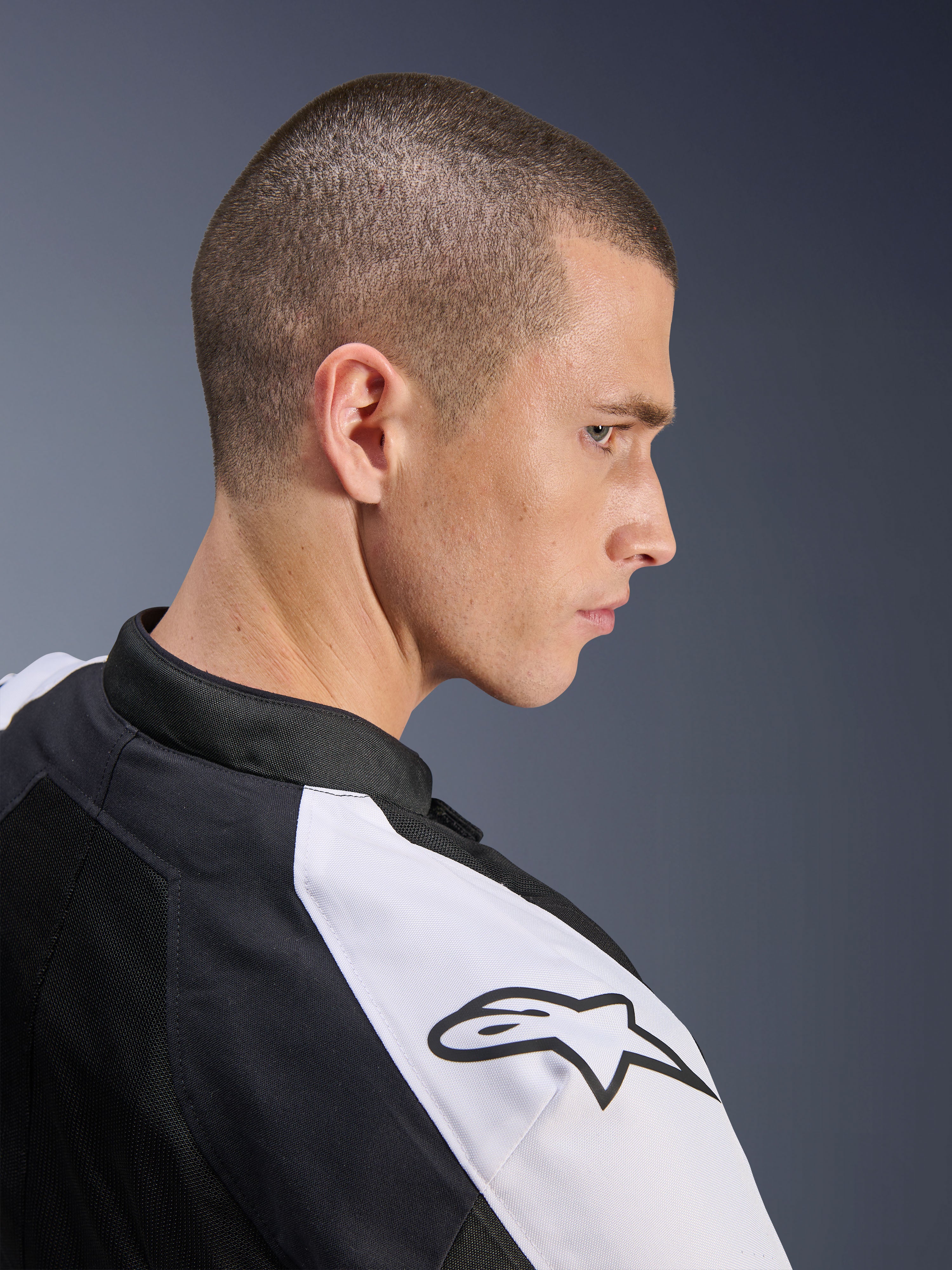 Kurtka Alpinestars Viper Air V4, czarno-biała, profil boczny modela w kurtce, biały panel na ramieniu z czarnym logo Alpinestars, konstrukcja z siatki technologicznej zapewniająca wentylację, sportowa motocyklowa odzież szosowa