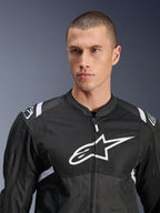 Kurtka Alpinestars T-SPS Air V2, tekstylna kurtka motocyklowa, czarno-biała, z dużym białym logo na klatce piersiowej i panelami z siatki, sportowy krój, prezentowana na modelu