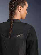 Alpinestars Stella T-Dyno Air Jacket, damska czarna kurtka motocyklowa, zbliżenie na tył pokazujące panele z siatki 3D na karczku i górnej części pleców dla przepływu powietrza, małe białe logo gwiazdy, modelka z warkoczem