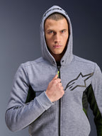 Alpinestars Chrome Air Sport Hoodie, szary melanż i czarny, motocyklowa bluza z kapturem noszona przez mężczyznę z założonym kapturem, czarne logo gwiazdy na piersi, neonowożółty uchwyt zamka, siatkowe panele boczne zapewniające wentylację, miejski styl jazdy