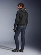 Alpinestars Chrome Superairflow Hoodie, czarna, widok z tyłu na modelu, z białym logo Alpinestars na kapturze, noszona z ciemnymi jeansami i czarnymi rękawicami, miejski styl motocyklowy