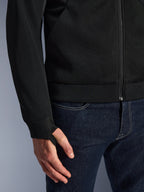 Alpinestars Chrome Superairflow Hoodie, czarna, zbliżenie na wysokoodporną techniczną siatkę 3D, prążkowany elastyczny mankiet z dżerseju z elastyczną pętelką na kciuk, noszona z niebieskimi dżinsami