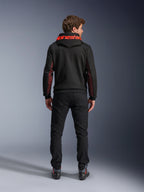 Alpinestars Chrome Air Sport Hoodie, czarno-czerwona (Black Red Fluo), widok z tyłu na mężczyznę w miejskiej kurtce motocyklowej, czerwony napis Alpinestars na kapturze, czerwone panele z siatki na rękawach, czarne spodnie