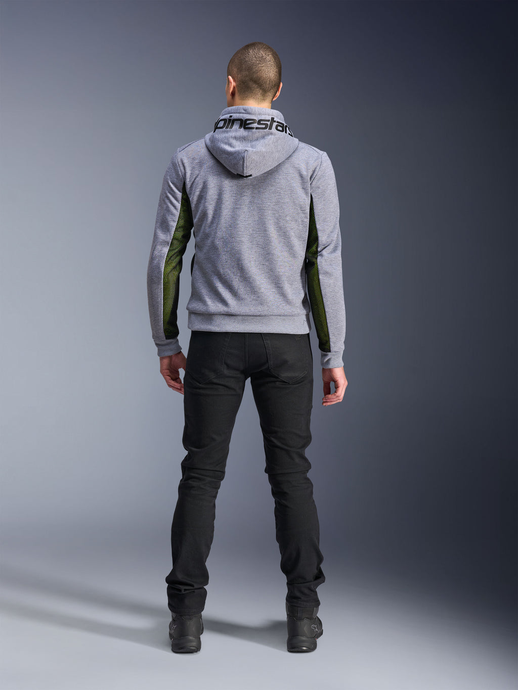 Alpinestars Chrome Air Sport Hoodie, Gray Heather Black, widok od tyłu motocyklowej bluzy z kapturem z zielonymi panelami z siatki o wysokim przepływie powietrza na bokach i rękawach, konstrukcja z technicznego polaru z logo Alpinestars na kapturze, zestawiona z czarnymi spodniami