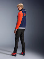 Alpinestars MM93 Chrome V2 Sport Hoodie, granatowo-szara bluza z kapturem z jaskrawoczerwonymi rękawami, branding MM93 Marc Marquez na plecach, model w ciemnych dżinsach i czerwonych butach motocyklowych, codzienna miejska odzież motocyklowa