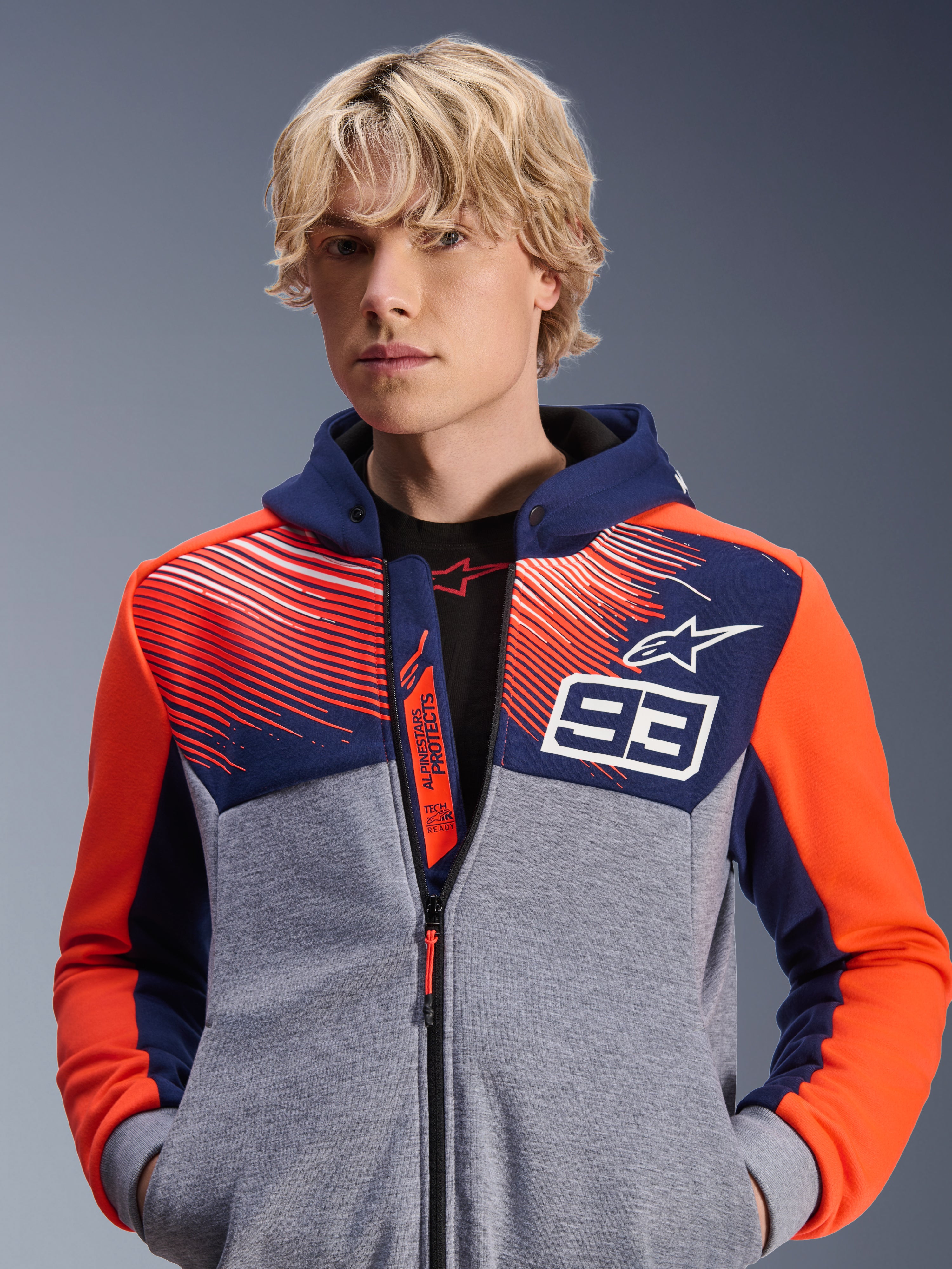 Alpinestars MM93 Chrome V2 Sport Hoodie, miejska bluza motocyklowa, granatowa i szary melanż z fluorescencyjnymi czerwonymi akcentami, z brandingiem Marc Marquez 93 i logo Alpinestars, fason z pełnym zamkiem, codzienna odzież lifestyle dla motocyklistów