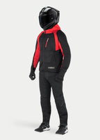 Kurtka z kapturem Alpinestars MO.ST.EQ Hybrid w kolorze Black Flame Red, miejska bluza motocyklowa z czerwonym kapturem i akcentami na ramionach, noszona z czarnym kaskiem integralnym i spodniami motocyklowymi, nowoczesny design inspirowany stylem streetwearowym