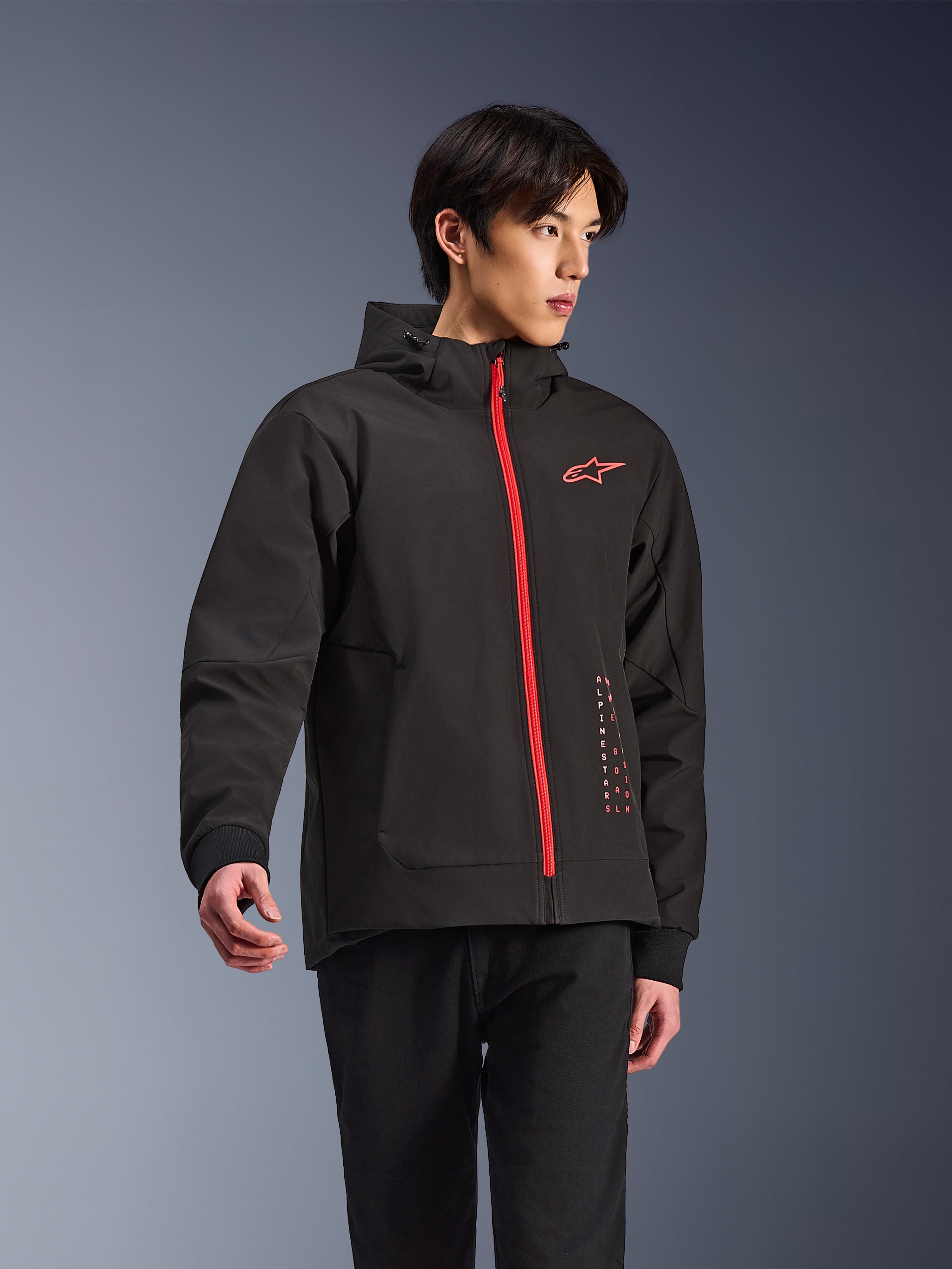 Alpinestars Radium Tech Hoodie, miejska kurtka motocyklowa, czarna z jaskrawoczerwonym zamkiem błyskawicznym, czerwone logo Alpinestars na piersi i czerwony napis z boku, techniczna wiatroszczelna powłoka z kapturem i ściągaczami, nowoczesny styl miejski dla motocyklistów
