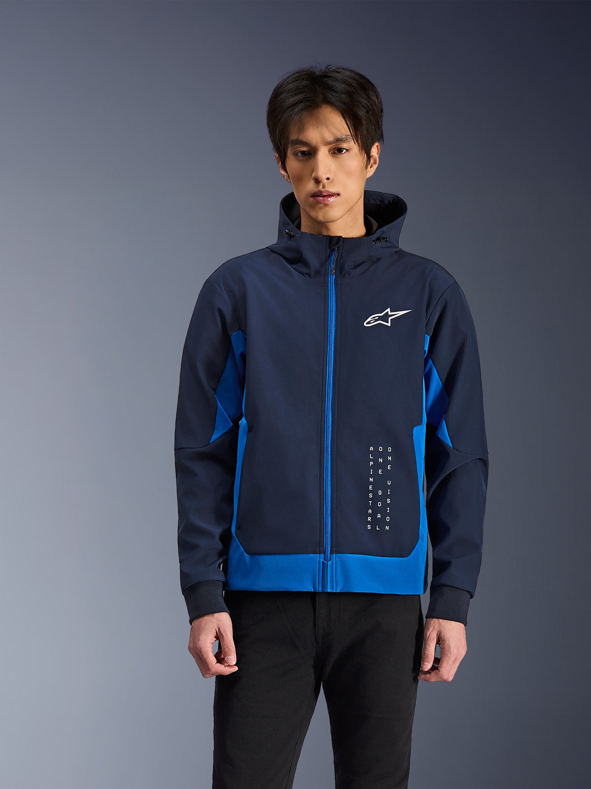 Alpinestars Radium Tech Hoodie, miejska kurtka motocyklowa, granatowa i niebieska, z przednim zamkiem, białym logo na piersi i pionowymi napisami, techniczna konstrukcja shell o sportowym kroju