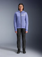 Alpinestars Stella Chrome V2 Sport Hoodie, damska fioletowo-niebieska bluza z białym logo Astars na piersi, techniczna bluza z kapturem zapinana na zamek, noszona z czarnymi spodniami motocyklowymi i butami do jazdy, codzienna miejska odzież motocyklowa dla kobiet