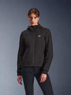 Alpinestars Stella Radium Tech Hoodie, damska motocyklowa bluza z kapturem, czarna, fason zapinany na zamek z okrągłym logo na piersi i kapturem, techniczna odzież do jazdy miejskiej, prezentowana przez modelkę