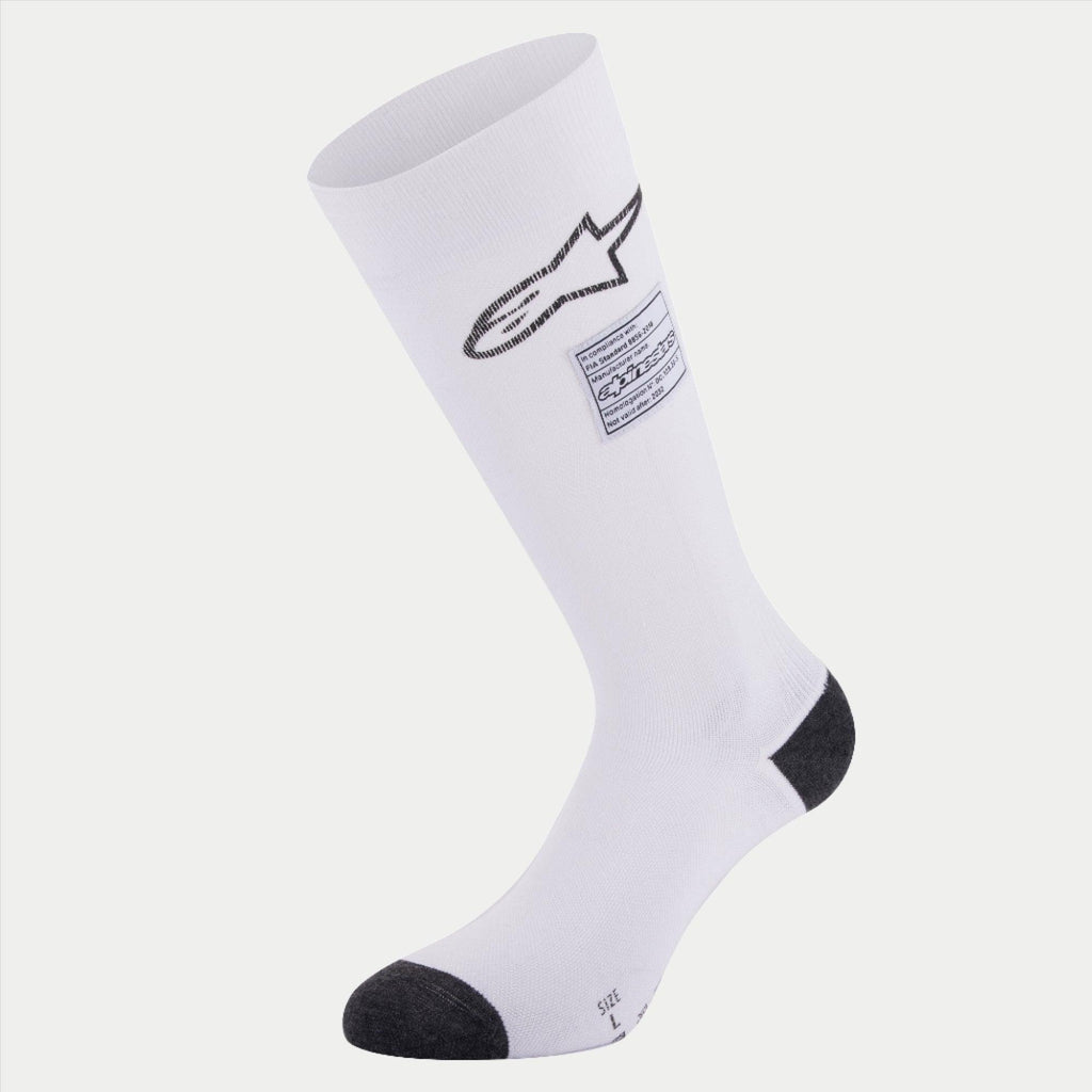 Skarpety Alpinestars ZX V4, samochodowe skarpety wyścigowe, białe z czarnymi akcentami na pięcie i palcach, z czarnym logo Alpinestars i etykietą zgodności FIA, bezszwowa techniczna warstwa bazowa do sportów motorowych
