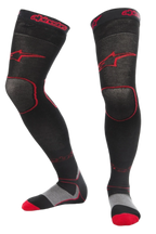 Alpinestars MX Long Tech Thick Socks, skarpety motocrossowe, czarno-czerwone, długość do połowy uda z czerwonym logo, szare i czerwone detale na podeszwie, techniczna tkanina przeznaczona do wyścigów off-road i butów motocrossowych