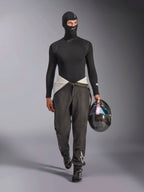 Kominiarka Alpinestars ZX Evo V3, czarna, model w pełnym stroju wyścigowym typu base layer z koszulką z długim rękawem i szarymi spodniami, kask z włókna węglowego z opalizującym wizjerem, profesjonalny sprzęt do wyścigów samochodowych