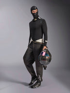 Alpinestars ZX Evo V3 Balaclava, czarna kominiarka noszona przez kierowcę w pełnym zestawie samochodowej bielizny termoaktywnej, białe logo na czole, kask z włókna węglowego z opalizującym wizjerem, profesjonalna ognioodporna odzież motorsportowa