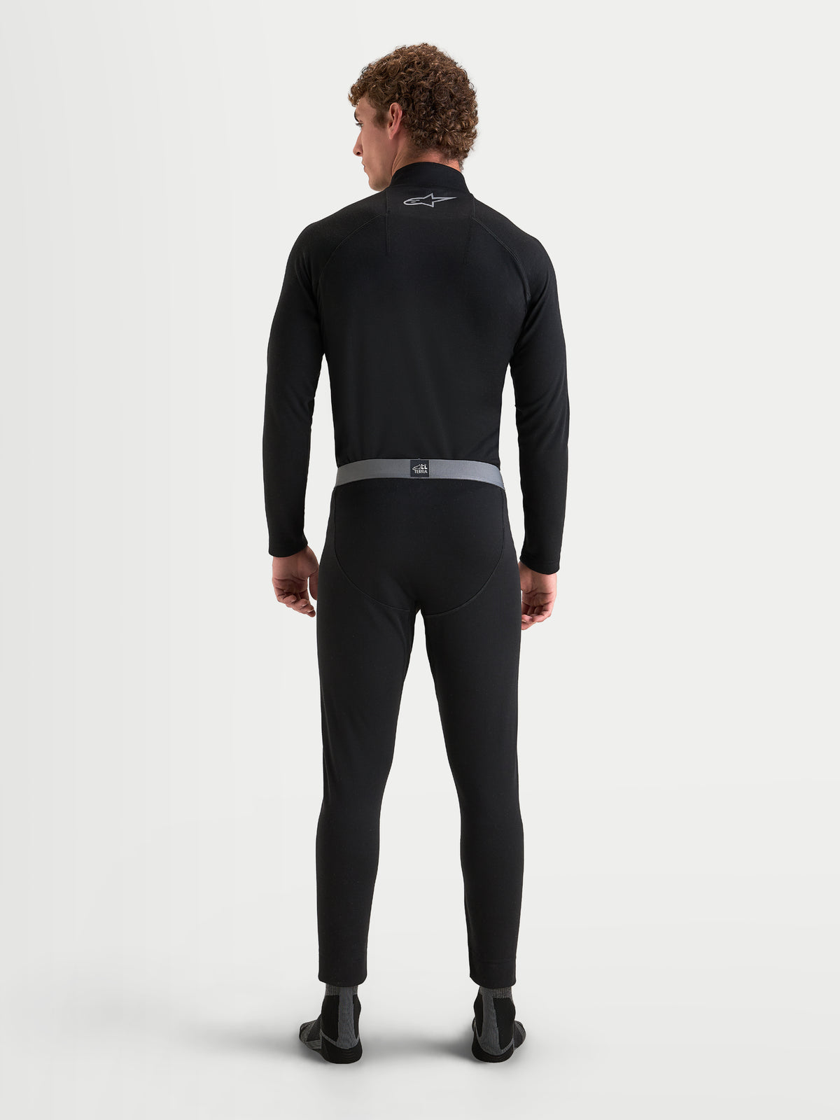 Alpinestars AT-8 Merino Top Layer i Bottom Base Layer, męski zestaw bielizny technicznej na motocykl adventure w kolorze czarnym, widok z tyłu na model prezentujący dwuwarstwową konstrukcję z wełny merynosa i ergonomiczny krój