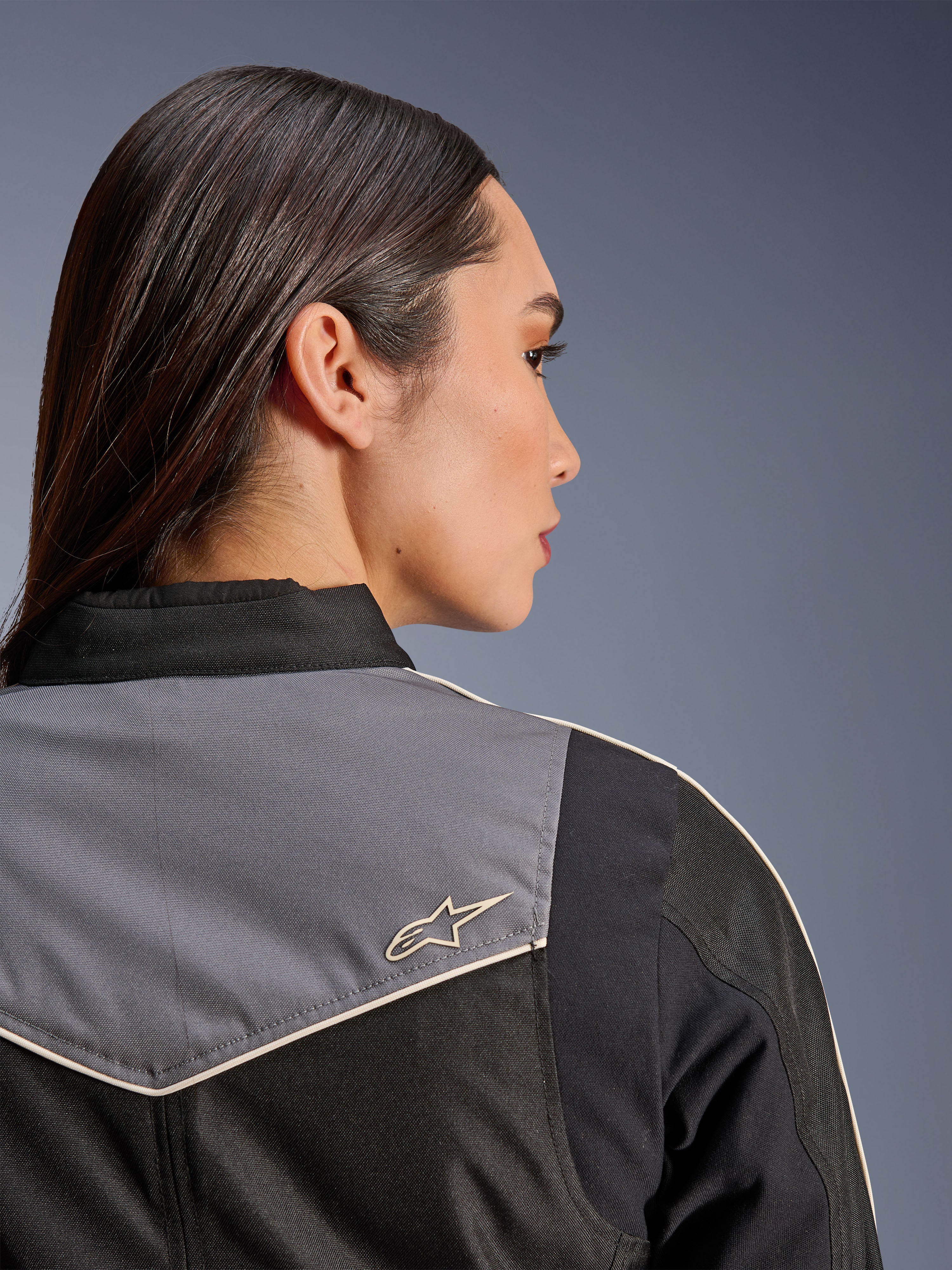 Alpinestars Stella T-Dyno WR Jacket, damska kurtka motocyklowa, czarna, ciemnoszara i ecru, zbliżenie na tył barku i karczek z szarym panelem i logo gwiazdy w kolorze ecru, odzież motocyklowa inspirowana stylem vintage