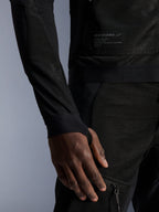 Alpinestars Troop-Air Jacket, czarna, zbliżenie na techniczną konstrukcję z siatki, markowa naszywka z tekstem technicznym, rękaw ze zintegrowanym otworem na kciuk, miejska letnia kurtka motocyklowa zapewniająca wysoki przepływ powietrza