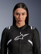 Modelka w kurtce Alpinestars Stella T-SPS Air V2, damska kurtka motocyklowa, czarno-biała, z oddychającymi panelami z siatki i białym logo Alpinestars na klatce piersiowej, sportowy design do jazdy szosowej