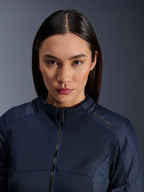 Modelka w ciemnoniebieskiej kurtce Alpinestars Stella C-1 Air, zbliżenie ukazujące teksturę oddychającej siatki, zamek błyskawiczny z przodu oraz logo Alpinestars na kołnierzu, stylowa miejska odzież motocyklowa