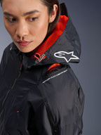 Alpinestars Molly Air Jacket, damska kurtka motocyklowa, kolor czarny i neonowy koralowy, zbliżenie na ramię eksponujące komorę na ochraniacz Nucleon Flex oraz białe logo Astars na kapturze, miejska odzież motocyklowa z tkaniny ripstop