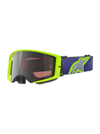 Gogle Alpinestars Supertech Vision Corp, gogle motocrossowe off-road, neonowo-żółte i fioletowe, srebrna lustrzana soczewka z napisem „One Goal One Vision”, fioletowy pasek z dużym neonowo-żółtym logo gwiazdy, czarna piankowa wyściółka, wytrzymała zakrzywiona konstrukcja soczewki