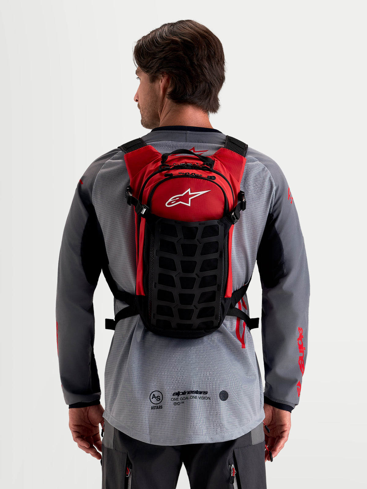 Alpinestars Plecak AT-9, plecak motocyklowy motocross, czarny i czerwony, widok od tyłu na model prezentujący lekką konstrukcję tekstylną i system wyściełanych szelków