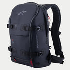 Alpinestars AMP-7 Backpack, techniczny plecak motocyklowy, czarny z czerwonymi akcentami przy zamkach, wyposażony w cztery regulowane paski kompresyjne z klamrami, usztywnione wyściełane ścianki, logo Alpinestars na górze i branding z boku, ergonomiczne paski na ramiona do jazdy typu adventure i road touring