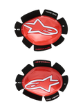 Alpinestars GP Tech Knee Sliders, czerwone i białe wyścigowe slidery kolan, duże białe logo gwiazdy na błyszczącym czerwonym plastiku, napis „ONE GOAL. ONE VISION.” na czarnym rzepie w kształcie płatków, para lewa i prawa do użytku na torze