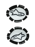 Slidery kolanowe Alpinestars GP Plus, biało-czarne, wyścigowe motocyklowe ochraniacze kolan, para prezentująca lewy i prawy slider z białymi plastikowymi powierzchniami i czarnym logo Astars, ząbkowane czarne rzepy z napisami „ONE GOAL” i „ONE VISION”