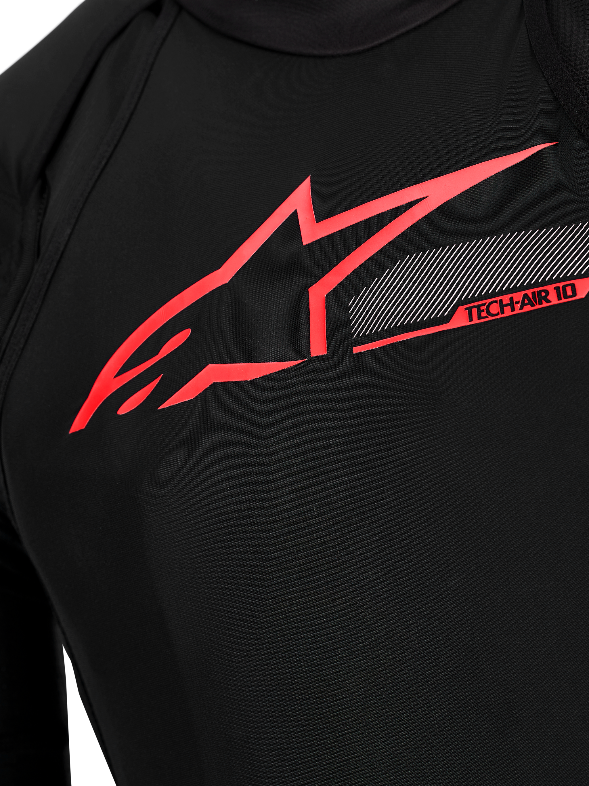 Tech-Air 10 V2 Race Airbag System chest detail, black technical fabric with bright red Alpinestars logo and tech graphics.