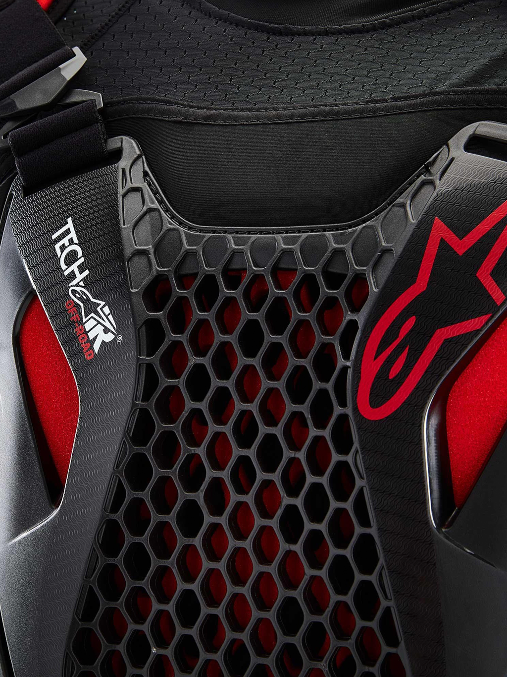 Alpinestars Tech-Air® Off-Road System, zbliżenie na detale off-roadowego systemu poduszki powietrznej, czarny i czerwony, ochrona klatki piersiowej Nucleon CELL w strukturze plastra miodu, branding Tech-Air i oddychająca siatkowa konstrukcja