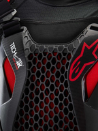 Alpinestars Tech-Air® Off-Road System, zbliżenie na detale off-roadowego systemu poduszki powietrznej, czarny i czerwony, ochrona klatki piersiowej Nucleon CELL w strukturze plastra miodu, branding Tech-Air i oddychająca siatkowa konstrukcja