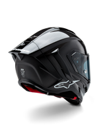 Kask Alpinestars Supertech R10 Solid, wyścigowy kask motocyklowy, czarne wykończenie z włókna węglowego (mat i połysk), widok z tyłu pod kątem trzech czwartych ukazujący karbonową skorupę, aerodynamiczny spojler oraz logo Alpinestars.