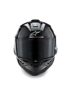 Kask Alpinestars Supertech R10 Solid, widok z przodu, czarny karbon w wykończeniu matowym i połyskującym, widoczny splot włókna węglowego, białe logo Alpinestars, ciemny dymiony wizjer, aerodynamiczny wyścigowy kask motocyklowy