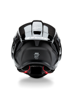 Alpinestars Supertech R10 Solid Helmet, kask motocyklowy, czarny karbon matowy i błyszczący, widok z tyłu prezentujący teksturę włókna węglowego, aerodynamiczny spojler z białym logo Alpinestars, etykiety certyfikacji bezpieczeństwa DOT i ECE oraz czerwona wyściółka wewnętrzna