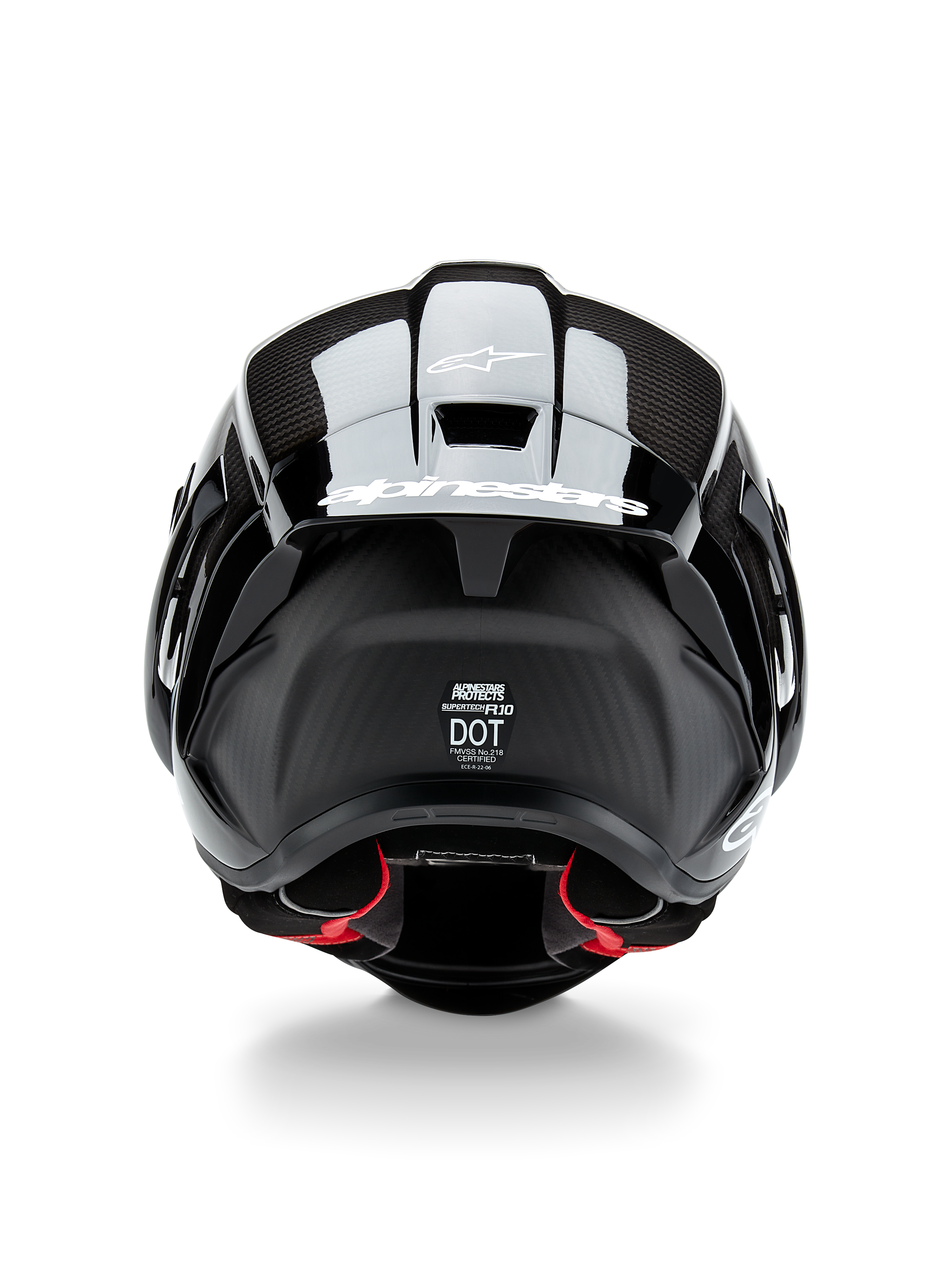 Alpinestars Supertech R10 Solid Helmet, kask motocyklowy, czarny karbon matowy i błyszczący, widok z tyłu prezentujący teksturę włókna węglowego, aerodynamiczny spojler z białym logo Alpinestars, etykiety certyfikacji bezpieczeństwa DOT i ECE oraz czerwona wyściółka wewnętrzna